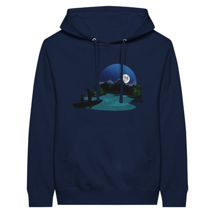 Navy premium hoodie featuring a print of two silhouetted figures fishing from a boat on a lake, with a full moon, mountains, and trees in the background.