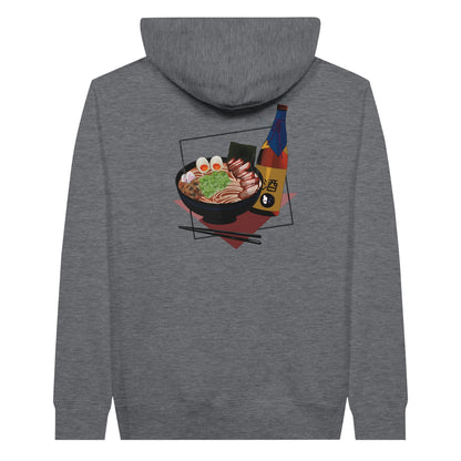 Charcoal heather coloured premium hoodie featuring a print of a steaming bowl of ramen with eggs, seaweed, and slices of meat, accompanied by a bottle of sake and chopsticks, set on a red geometric background.